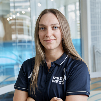 Close up image of personal trainer with arms crossed smiling